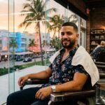 Hombre latino con un corte fade impecable en una barbería de Miami al atardecer.